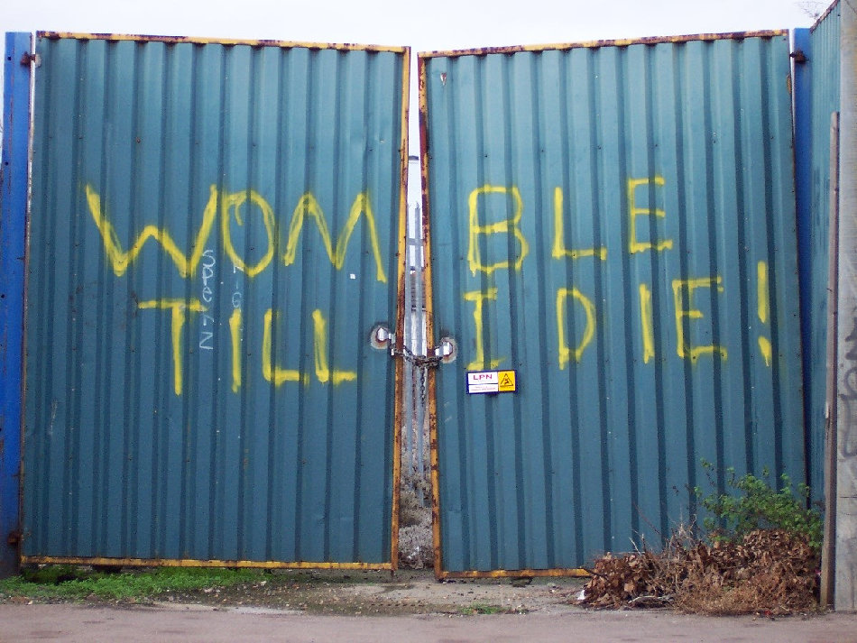Gates at Plough Lane with the graffiti "Womble Till I Die"